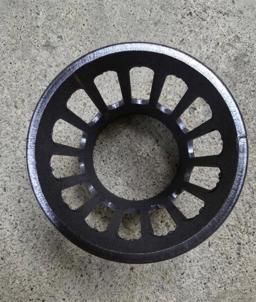 Dark oxide-finished steel ring with radial spoke-pattern slot cutouts