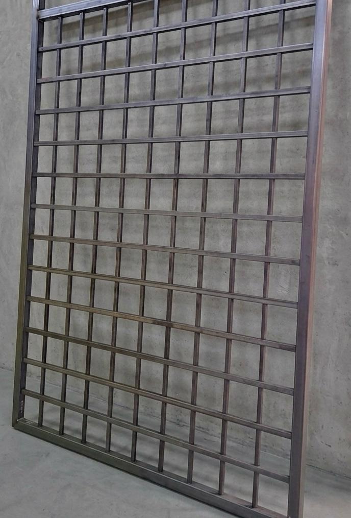 Large custom steel screen panel with a precise grid cutout pattern