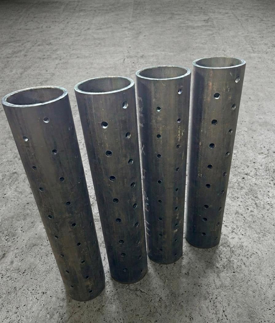 Four upright steel tube sections with precision-drilled hole patterns along their length