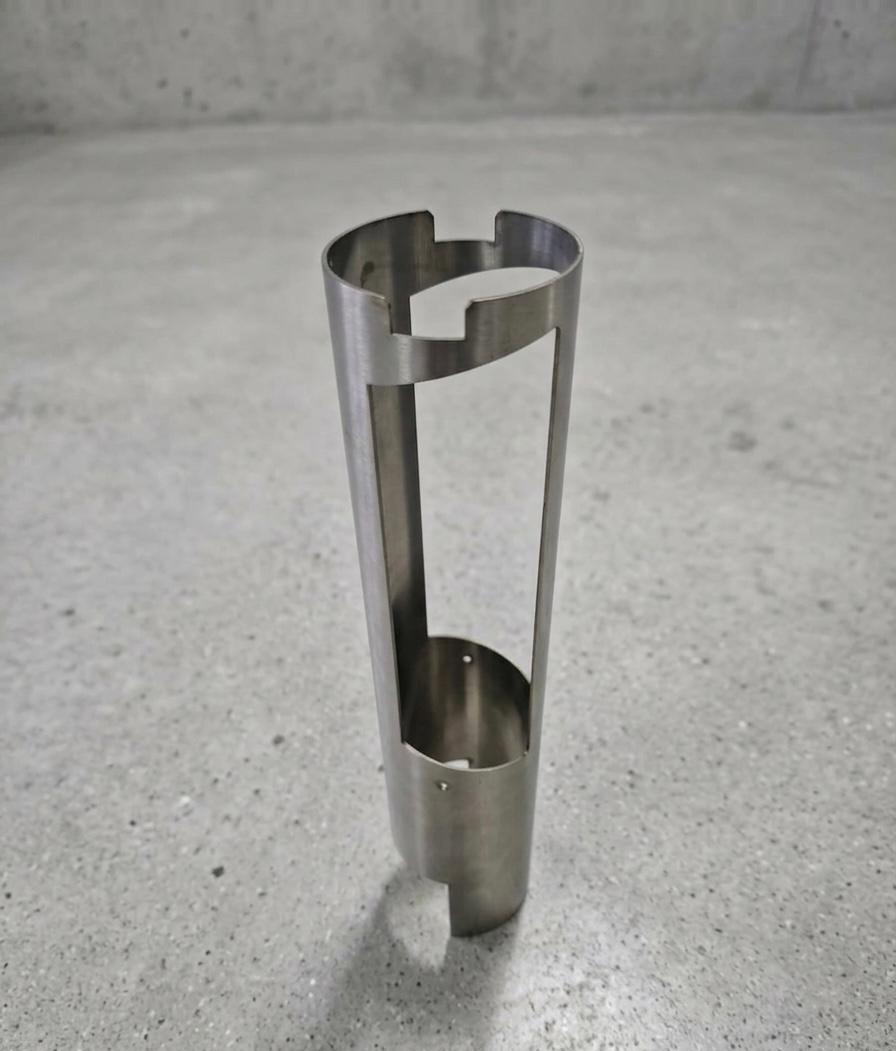 Stainless steel cylindrical component with notched rim and vertical slot cutouts
